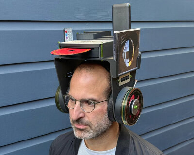 headphones carry CD player, remote and jewel case above user’s head for on-the-go music