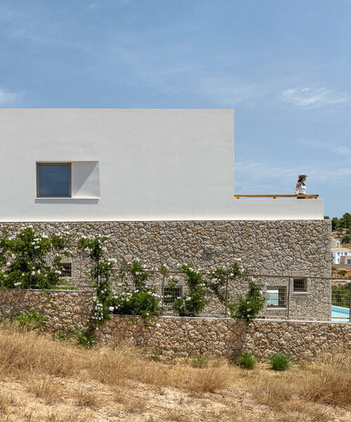 pieris.architects embeds layered stone-and-plaster residence into greek hillside