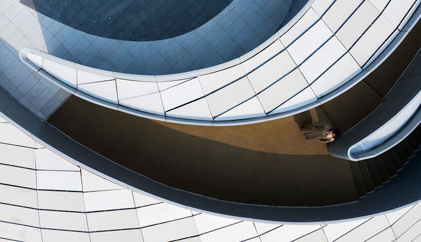 wutopia lab carves soft white caving interiors for pebble-shaped mountain hotel in china