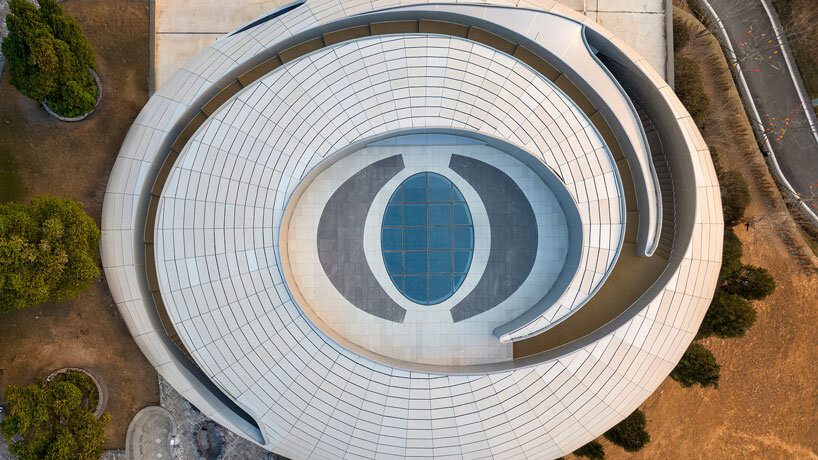 wutopia lab carves soft white caving interiors for pebble-shaped mountain hotel in china