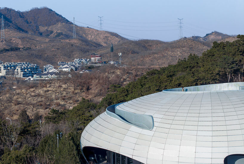 wutopia lab carves soft white caving interiors for pebble-shaped mountain hotel in china