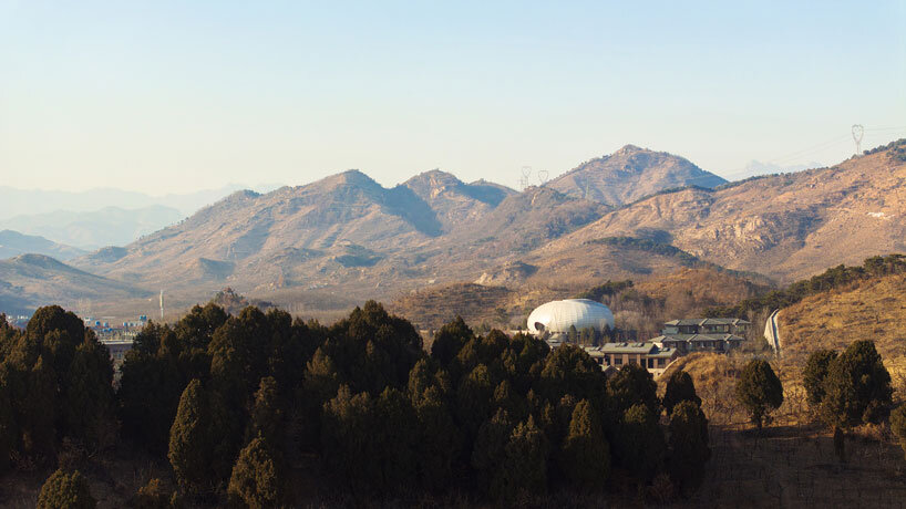 wutopia lab carves soft white caving interiors for pebble-shaped mountain hotel in china