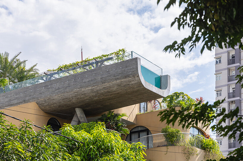rooftop pool cantilevers from the facade of ho khue architects' hotel in vietnam