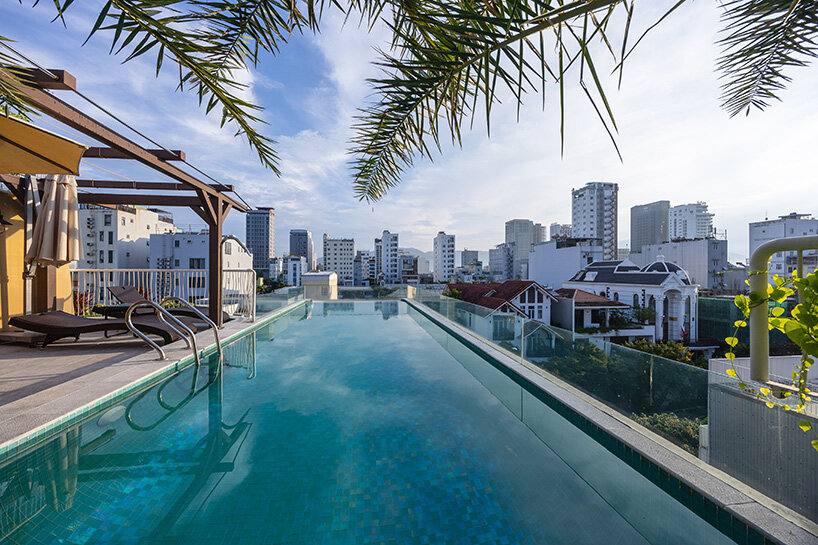 rooftop pool cantilevers from the facade of ho khue architects' hotel in vietnam