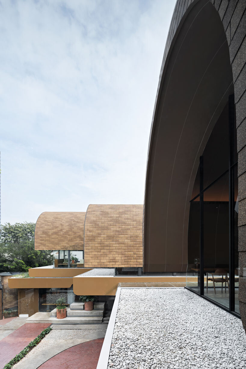 Cuatro refugios arqueados en Rad+AR se extienden en jardines inclinados en capas en el norte de Yakarta