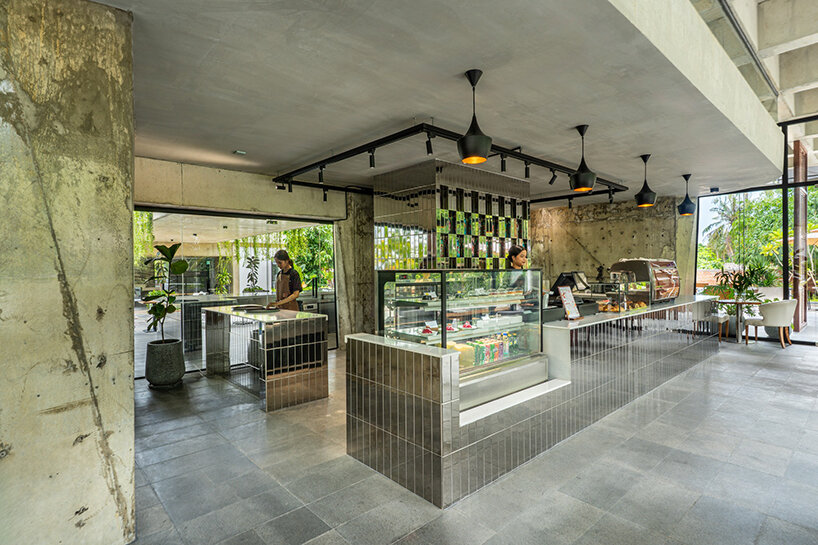 unfinished concrete structure turns into nature-filled tropical café in cambodia