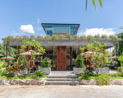 unfinished concrete structure turns into nature-filled tropical café in cambodia