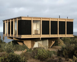 wooden beams sit atop concrete spiral staircase in lote studio’s elevated casa CG in chile
