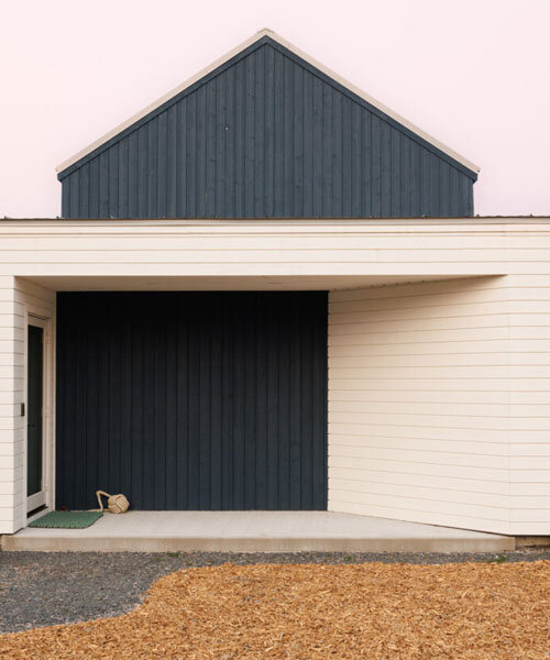 contrasting gable and mono-pitched metal roofs top wooden coley's point house in canada