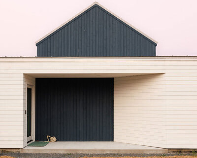 contrasting gable and mono-pitched metal roofs top wooden coley's point house in canada