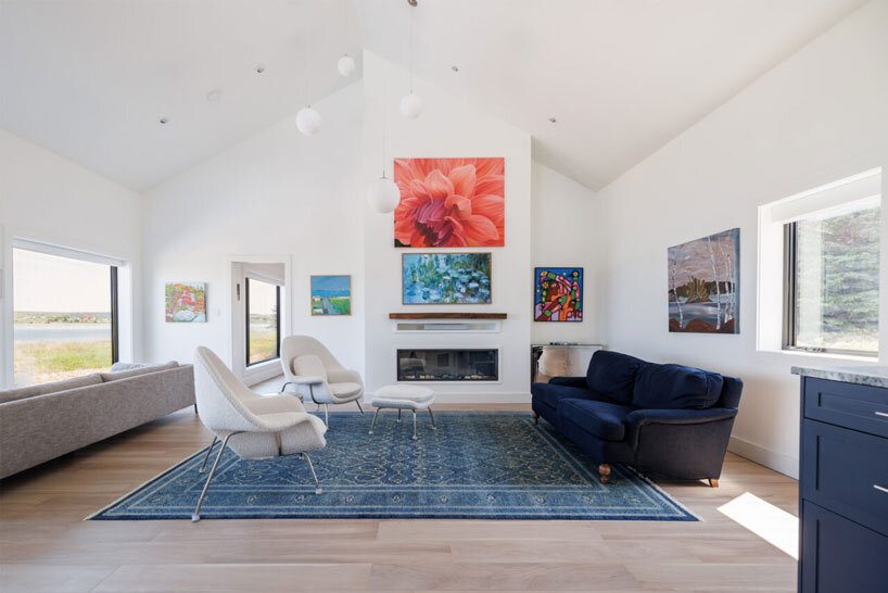 contrasting gable and mono-pitched metal roofs top wooden coley's point house in canada