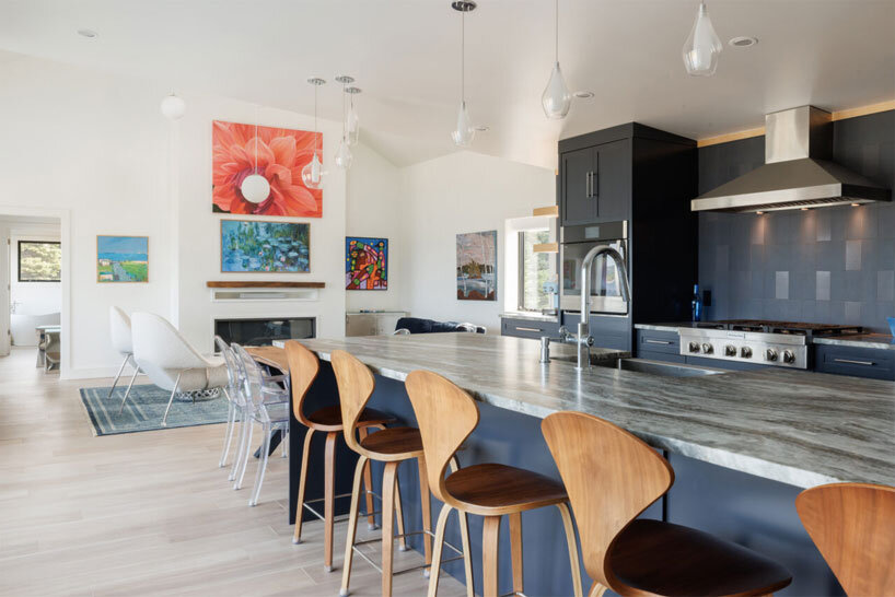 contrasting gable and mono-pitched metal roofs top wooden coley's point house in canada