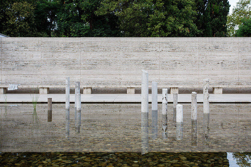 concrete sculptures surface from the pond of mies van der rohe's barcelona pavilion