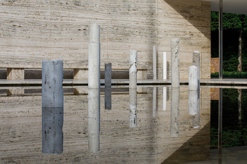 concrete sculptures surface from the pond of mies van der rohe's barcelona pavilion