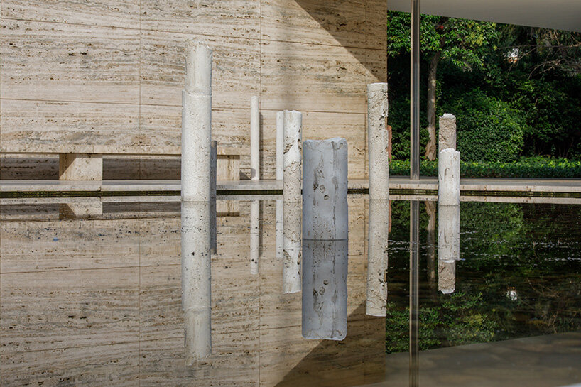 concrete sculptures surface from the pond of mies van der rohe's barcelona pavilion