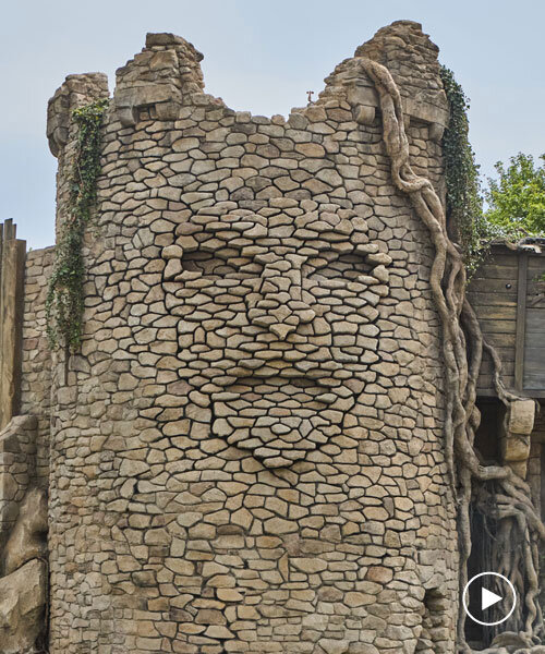 kinetic sculpture outlines moving face onto tower's stonework in french theme park