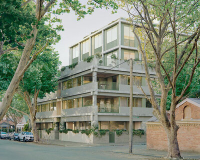 monolithic apartment complex contrasts with verdant fitzroy streetscape in melbourne