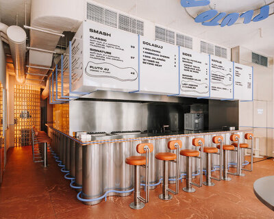 caramel tones and fluid undulating lines form melting interior of pluto burger bar in poland