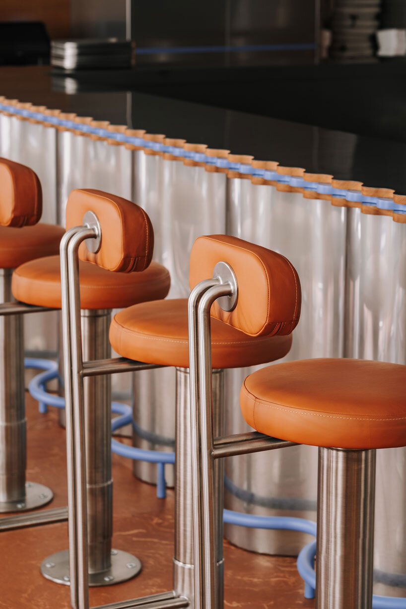 caramel tones and fluid undulating lines form melting interior of pluto burger bar in poland