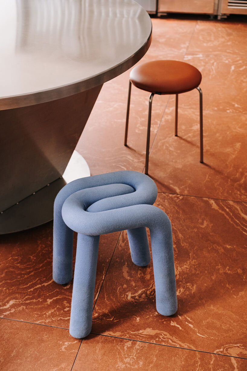 caramel tones and fluid undulating lines form melting interior of pluto burger bar in poland