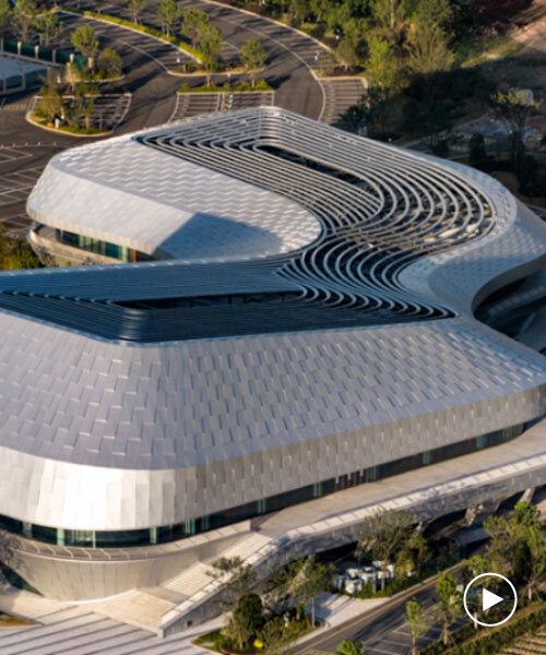 scale-like facade wraps hushan swimming center's undulating form by LYCS architecture