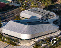 scale-like facade wraps hushan swimming center's undulating form by LYCS architecture