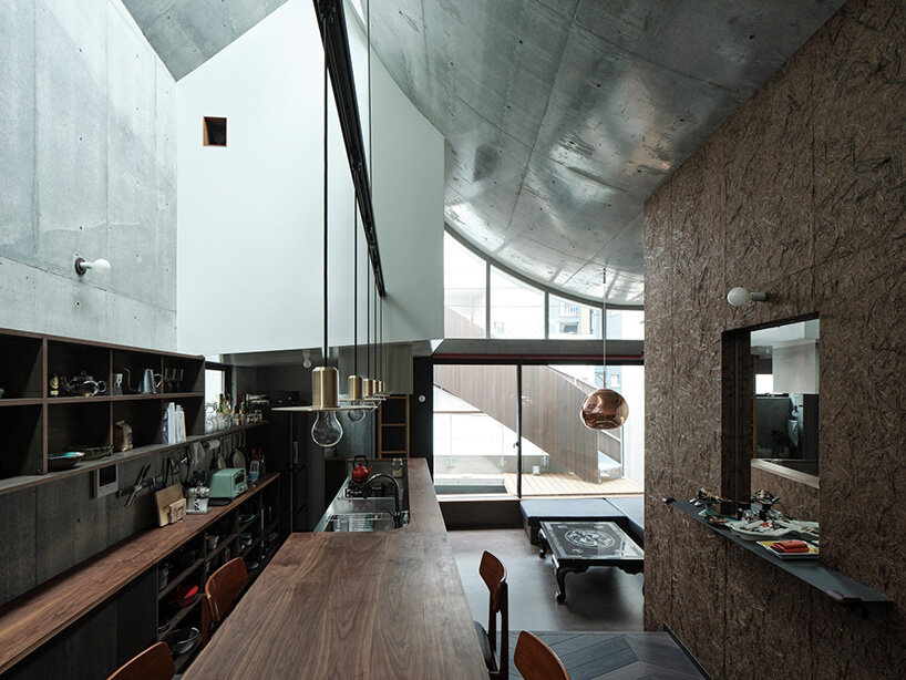 El techo semi-cilíndrico trae luz solar a la residencia de tres pisos de Aoim en Tokio