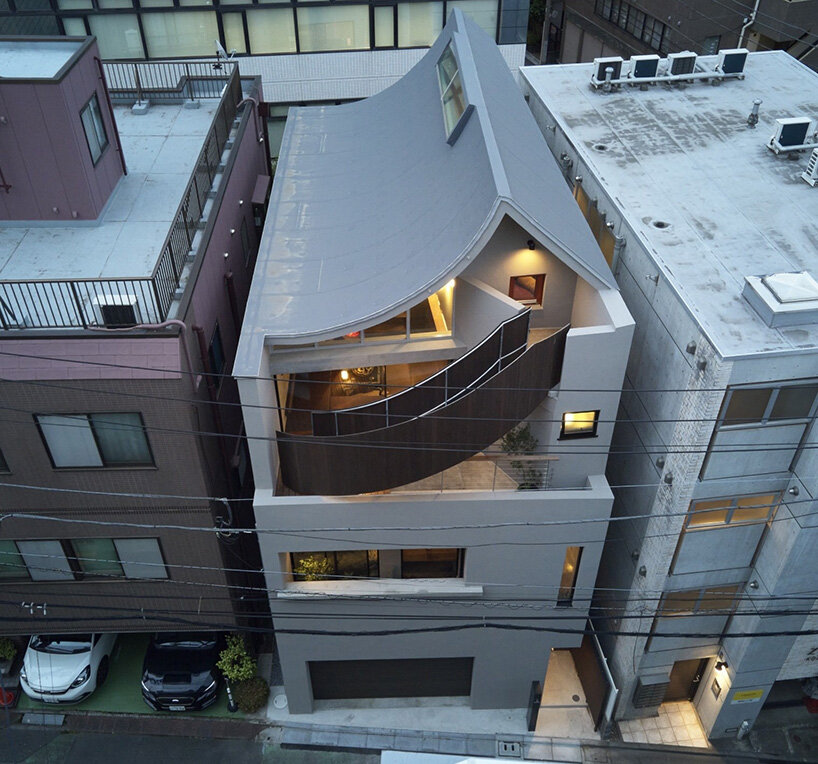 El techo semi-cilíndrico trae luz solar a la residencia de tres pisos de Aoim en Tokio