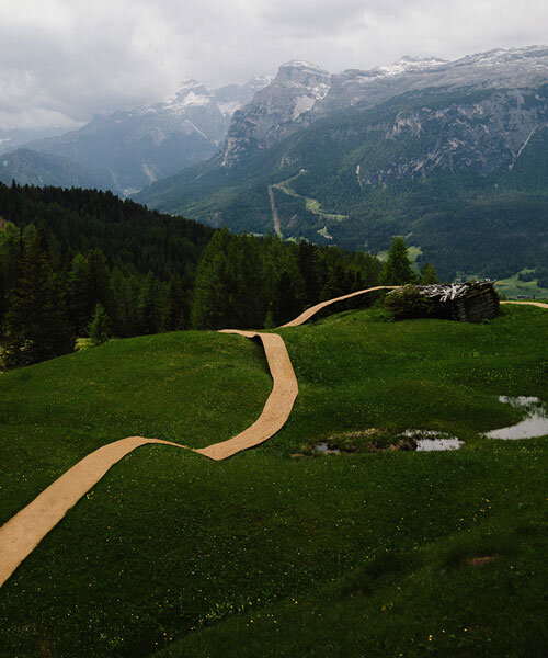 hay bales unroll into trace of land installation across alpine terrain in italy