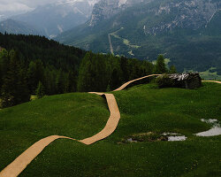 hay bales unroll into trace of land installation across alpine terrain in italy