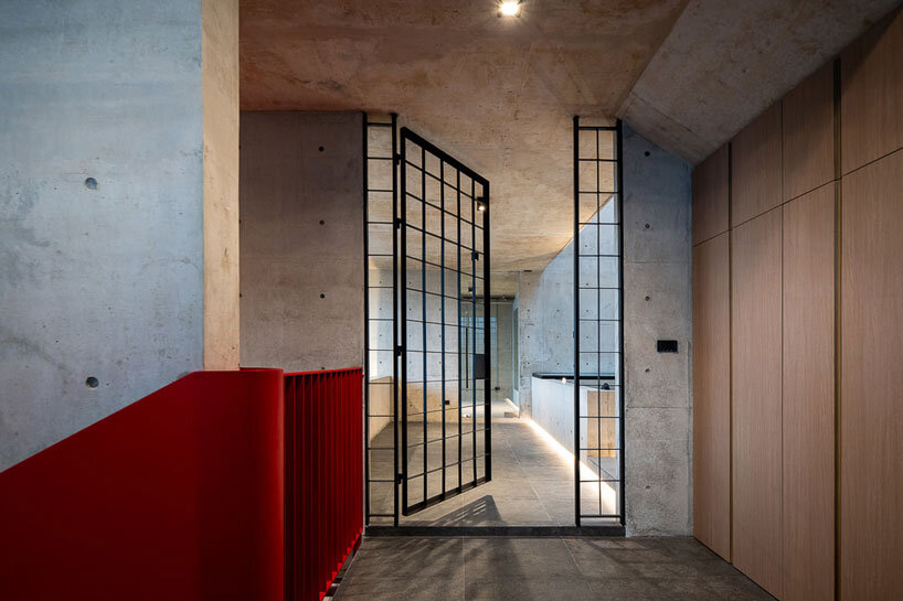 green courtyard anchors hybrid home and office within concrete structure in bangkok