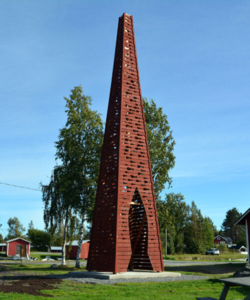 red timber pyramid beacon by ulf mejergren glows through fish cutouts on baltic sea island