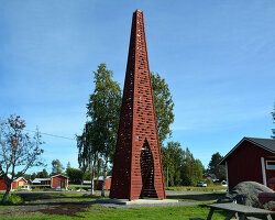 red timber pyramid beacon by ulf mejergren glows through fish cutouts on baltic sea island