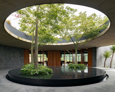 curved stone pavilion encloses circular reflecting pool for clubhouse in mexico