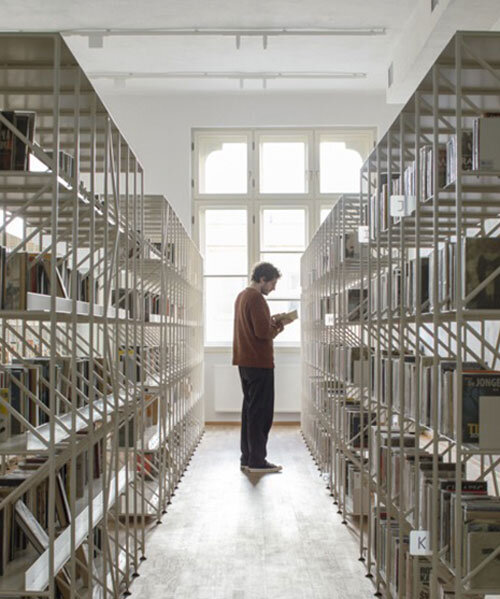 suspended steel shelving forms permeable curtain within revitalized historic slovak library
