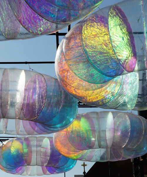 floating oculus installation shimmers in shifting chromatic light above brooklyn's streets
