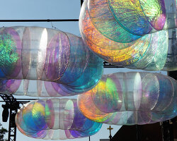 floating oculus installation shimmers in shifting chromatic light above brooklyn's streets