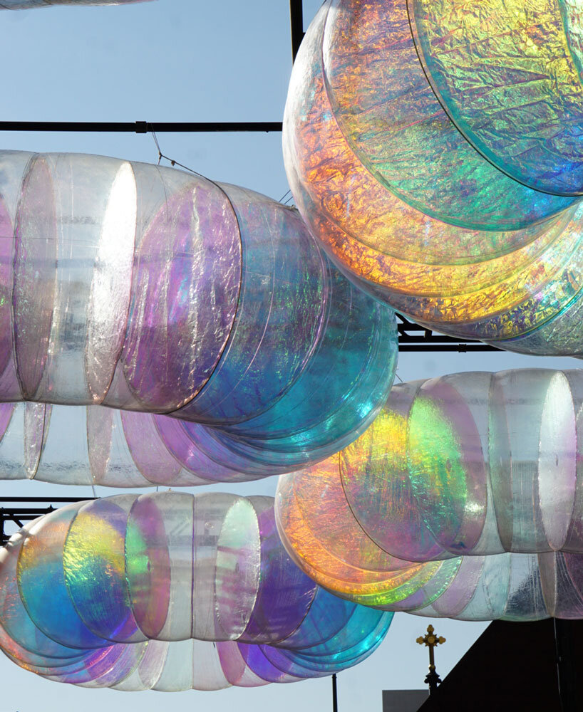 floating oculus installation shimmers in shifting chromatic light above brooklyn's streets