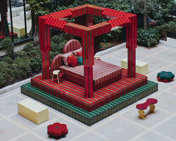 green and red ceramic tiles clad sculptural daybed by uchronia at hôtel plaza athénée, paris