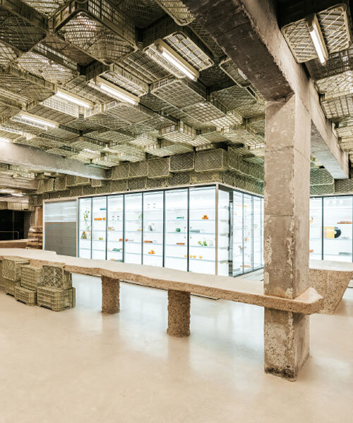 ceiling of recycled plastic crates expands over brutalist supermarket in mallorca