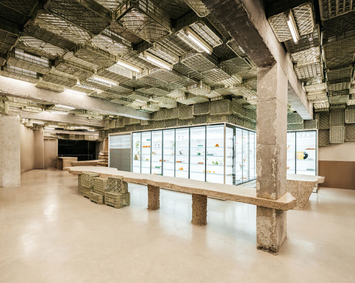 ceiling of recycled plastic crates expands over brutalist supermarket in mallorca