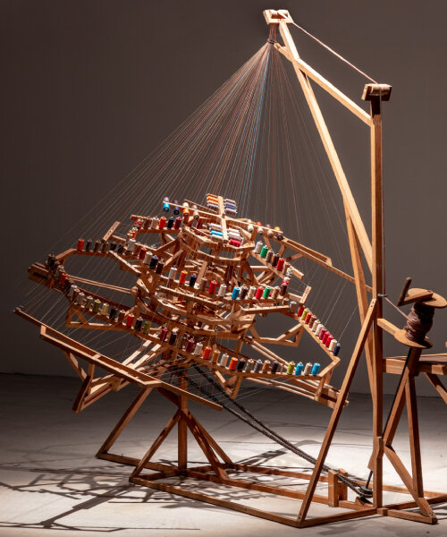rope-making machine by conrad shawcross weaves umbilical-like cords with motorized 'arms'