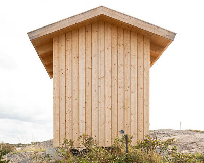 untreated wooden cladding wraps vernacular sauna sövall on sweden's rocky shoreline