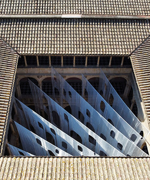 translucent organza curtains float within renaissance arched courtyard in spain