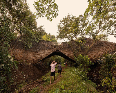 wallmakers wraps its suspended 'bridge house' in skin of thatched scales