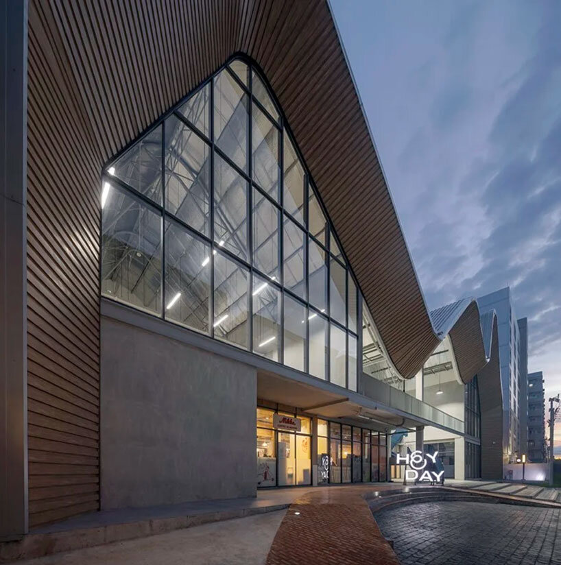 three asymmetrical curved gable roofs top ASWA’s community hub in thailand