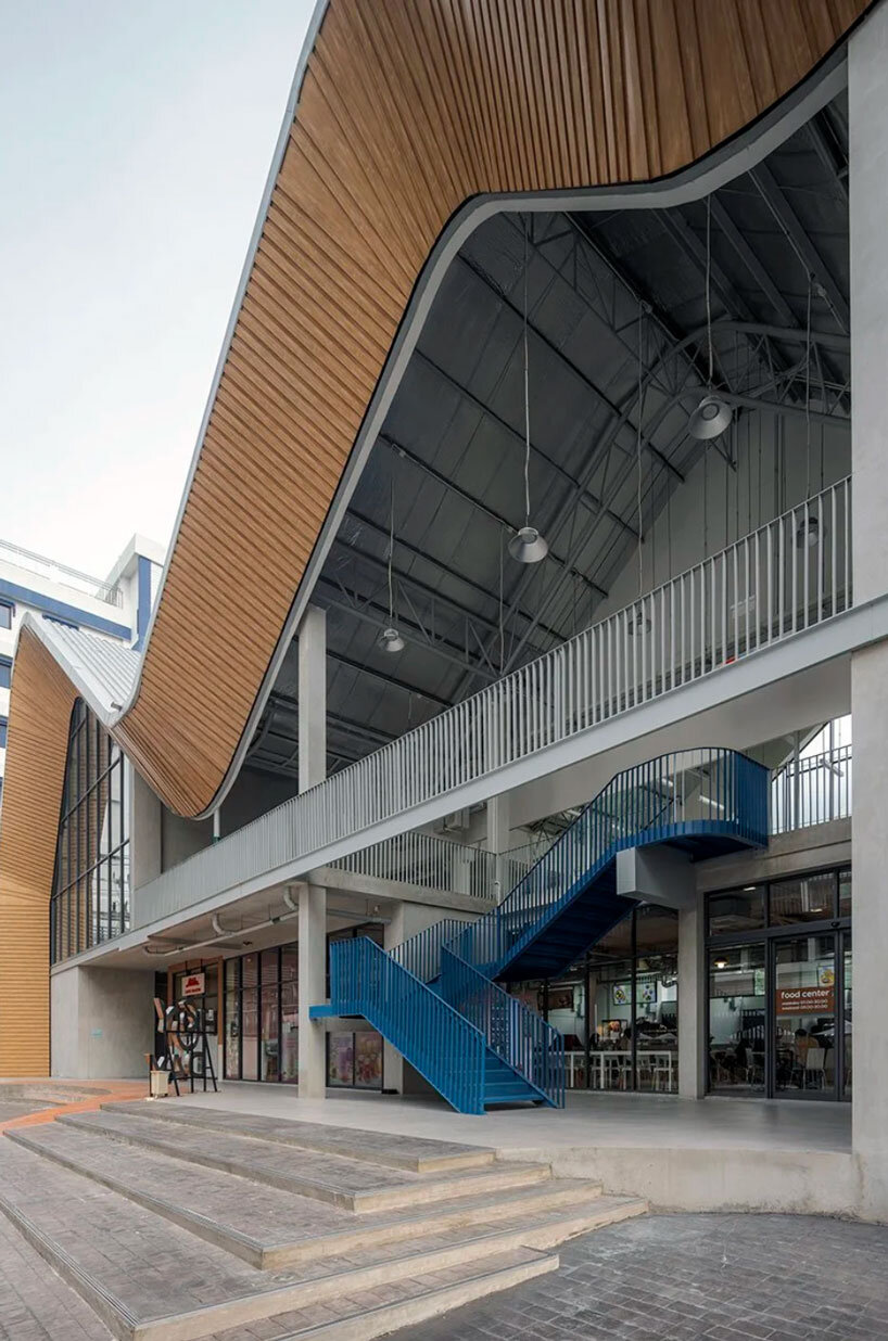 three asymmetrical curved gable roofs top ASWA’s community hub in thailand