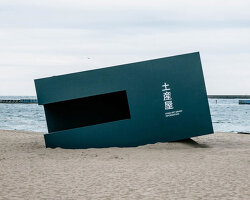 buried souvenir shop on japanese shoreline reflects on tourism, land, and memory