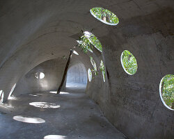 kong xiangwei's art museum is a rolled concrete shell-structure in the woods