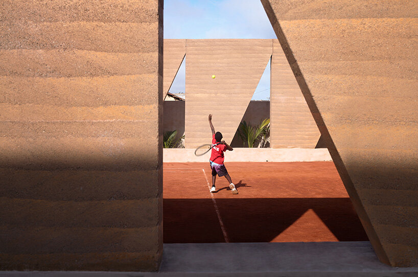 ghana’s first precast rammed earth project by deroche projects hosts community tennis court